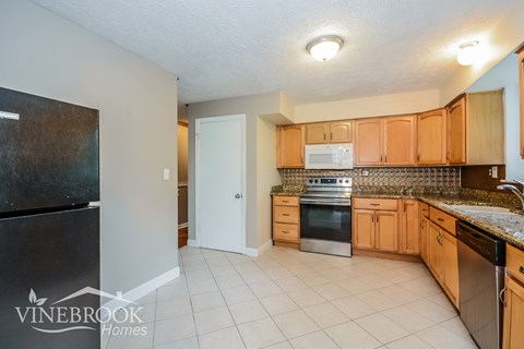 a kitchen with wooden cabinets and a stove and a refrigerator